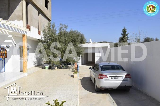 une maison avec garage sur la route principale